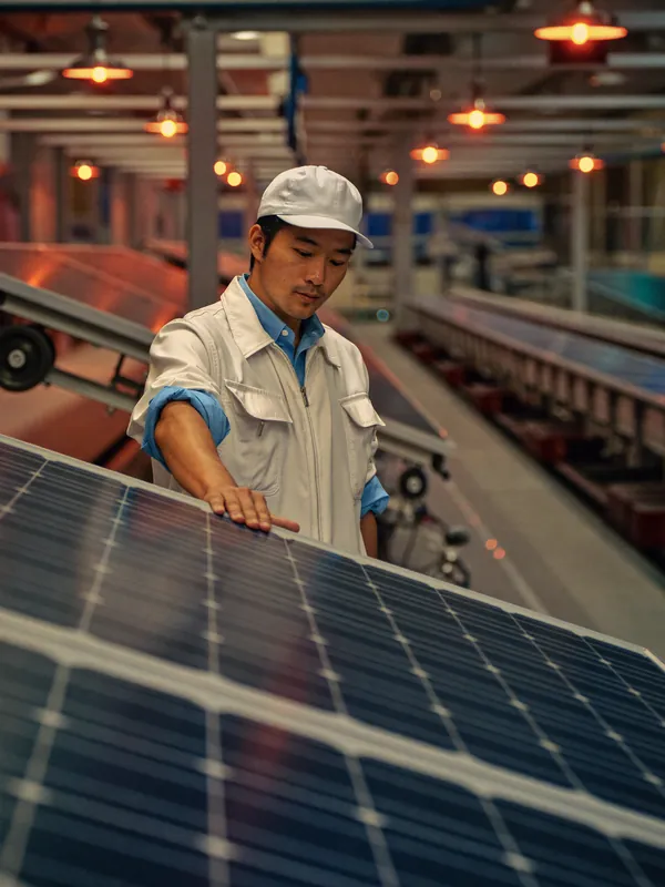 AI concept image: an engineer inspecting a solar panel on a production line